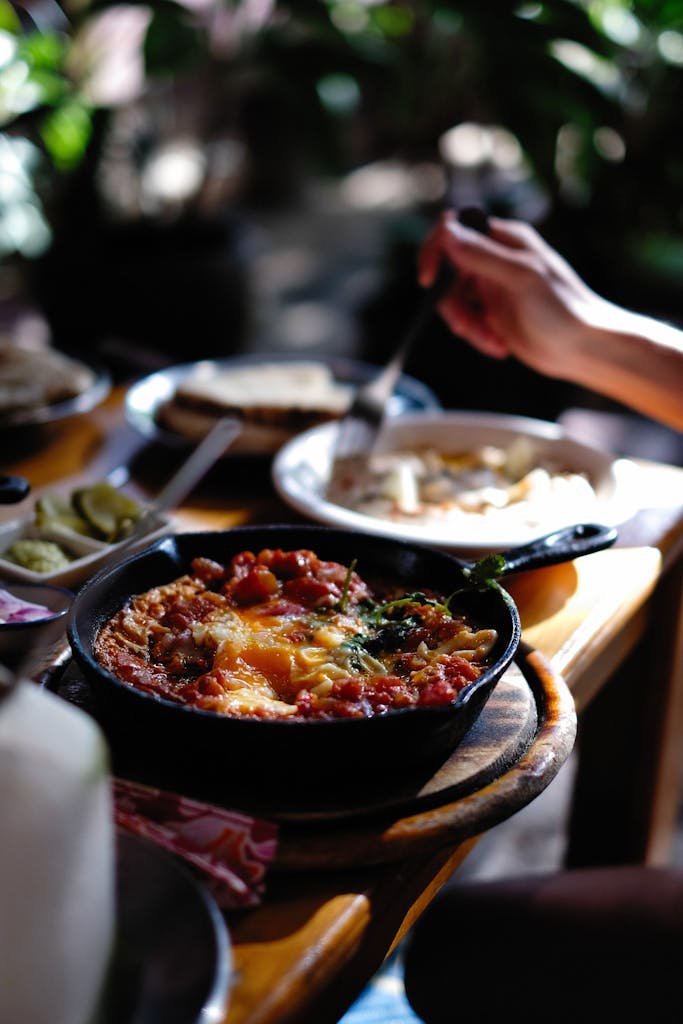 A close-up of a savory shakshuka served in a cast iron skillet on a wooden table, creating a cozy dining atmosphere.